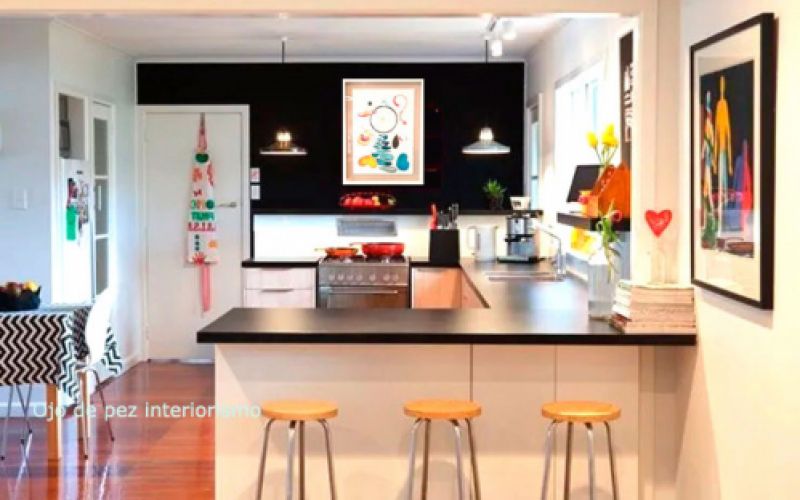 Cocina moderna con muebles en blanco y decorada con cuadros coloridos